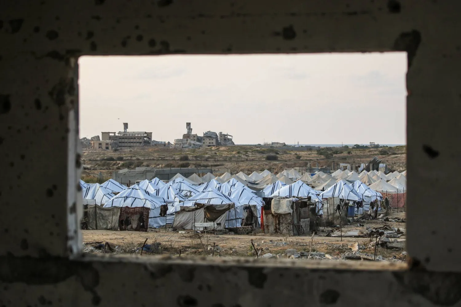 A general view of a new displacement camp set up by the Egyptian Committee is pictured through a window in Nuseirat, Gaza Strip on November 11, 2025. (AFP)