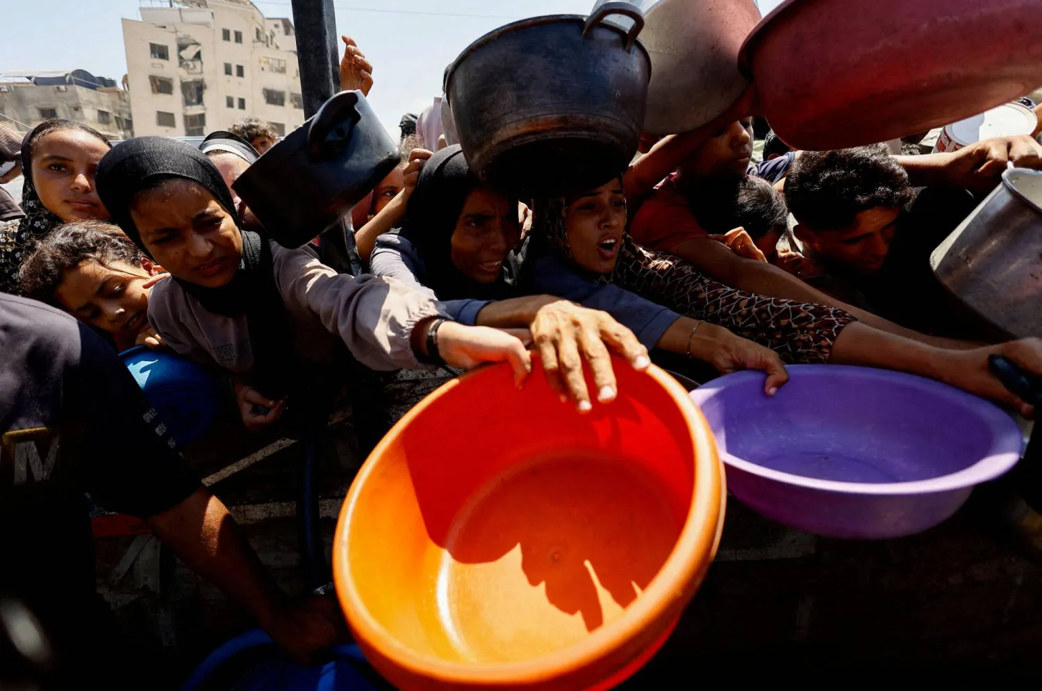 Palestinians wait to receive food from a charity kitchen in Gaza City, August 28, 2025. (Reuters) 