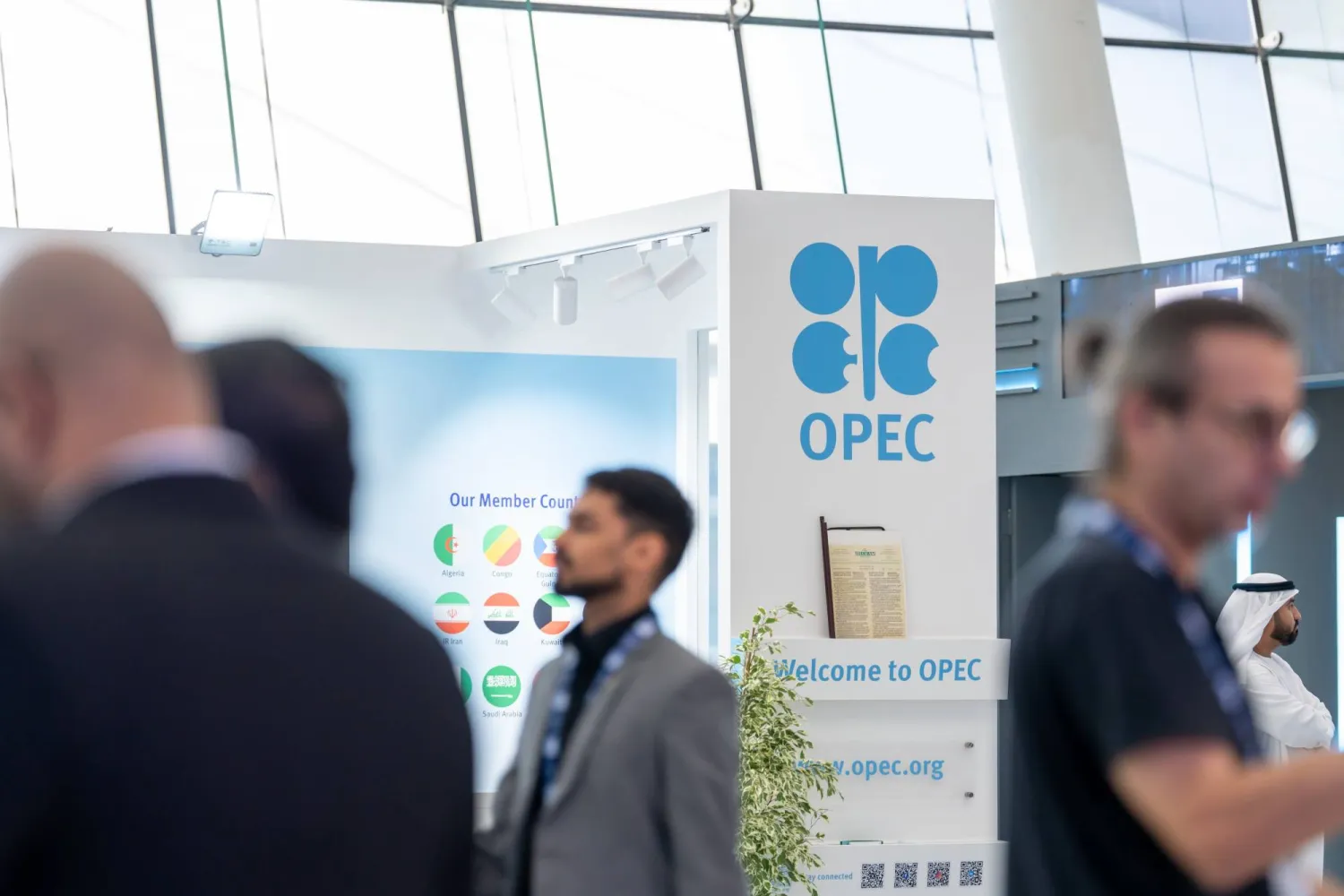 أشخاص يقفون إلى جانب جناح «أوبك» في مؤتمر «أديبك» (إكس)