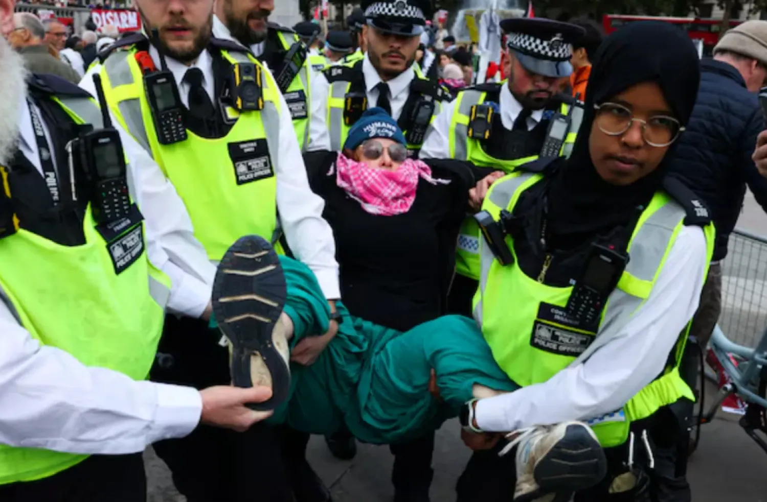 Police officers detain a protester during a mass demonstration organized by Defend our Juries, against the British government's ban on Palestine Action, at Trafalgar Square in London, Britain, October 4, 2025. REUTERS/Toby Melville
