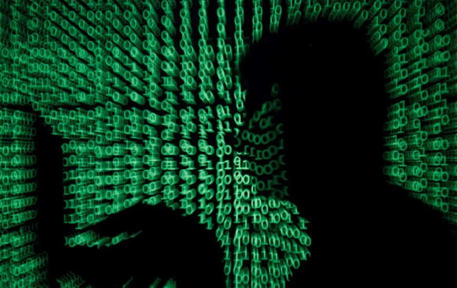 A man holds a laptop computer as cyber code is projected on him in this illustration picture taken on May 13, 2017. (Reuters)
