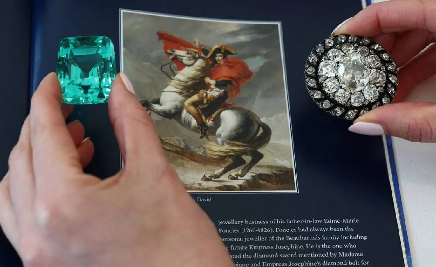  A staff member holds a 132.66 carats green beryl worn by Emperor Napoleon I at his coronation and an old mine-cut diamond brooch or pendant owned by Emperor Napoleon I during an auction preview for Sotheby’s in Geneva, Switzerland, November 6, 2025. (Reuters)