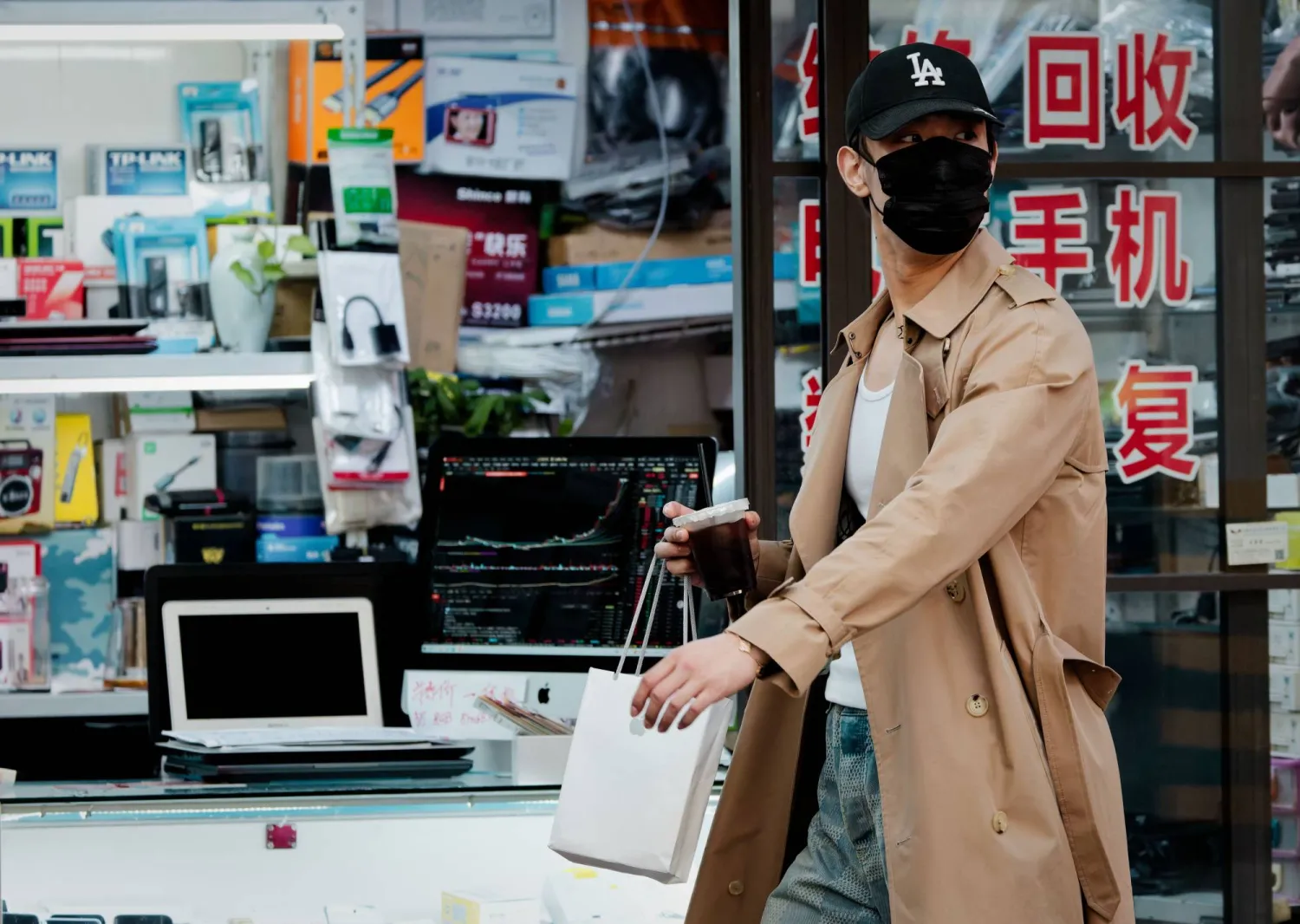 سيدة تمر أمام متجر للإلكترونيات في مدينة شنغهاي الصينية (إ.ب.أ)
