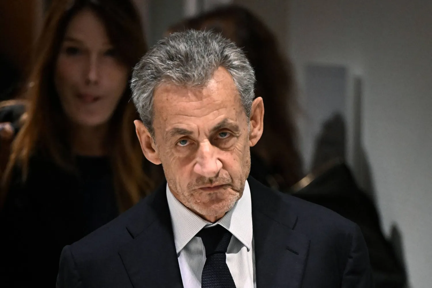 (FILES) Former French president Nicolas Sarkozy leaves in front of his wife French-Italian singer Carla Bruni after the verdict in his trial for illegal campaign financing from Libya for his successful 2007 presidential bid, at the Tribunal de Paris courthouse in Paris, on September 25, 2025. (Photo by JULIEN DE ROSA / AFP)
