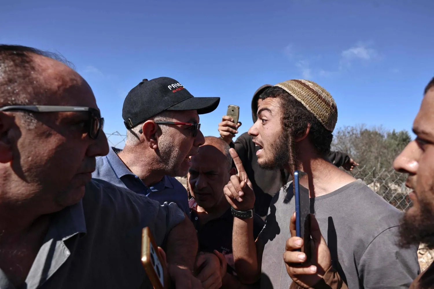 Palestinian farmers (L) scuffle with Israeli settlers during the olive harvest in the Palestinian village of Silwad, near Ramallah in the Israeli-occupied West Bank, on October 29, 2025.  (Photo by Zain JAAFAR / AFP)