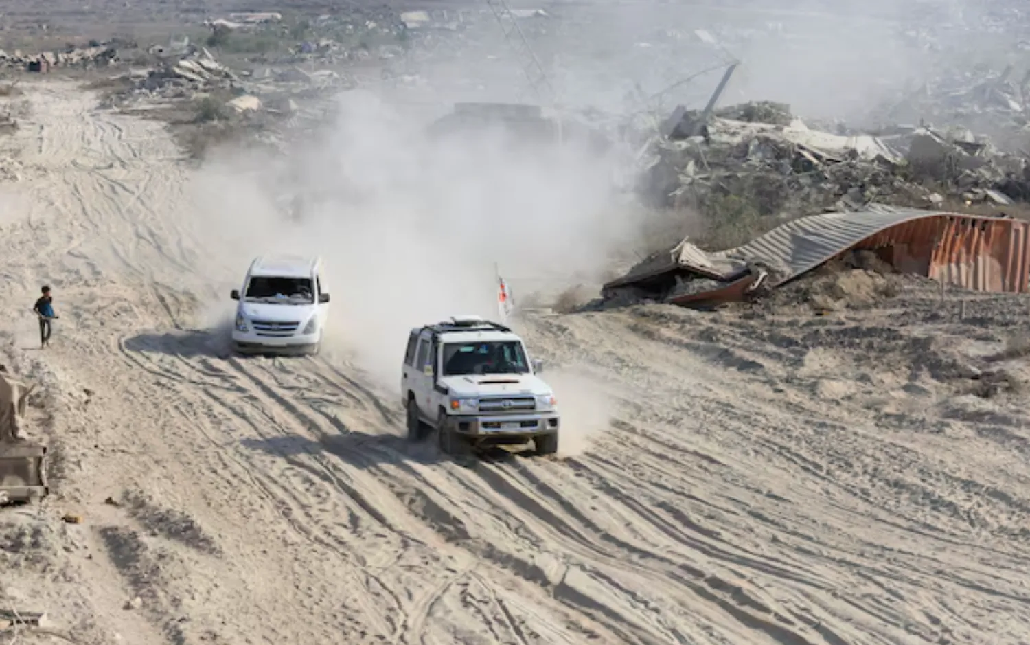 A Red Cross vehicle, escorted by a van driven by a Hamas militant, moves in an area within the so-called "yellow line" to which Israeli troops withdrew under the ceasefire, as Hamas says it continues to search for the bodies of deceased hostages seized during the October 7, 2023, attack on Israel, in Gaza City November 12, 2025 - Reuters 