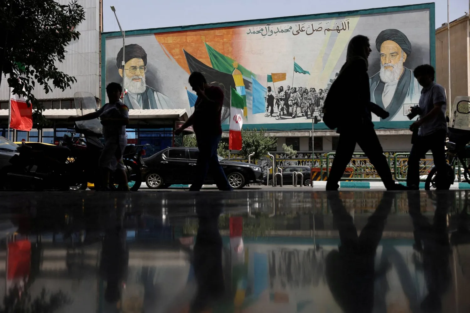 FILE PHOTO: People walk next to a mural with a picture of Iran's Supreme Leader, Ali Khamenei, on a street, early hours of ceasefire, in Tehran, Iran, June 24, 2025. Majid Asgaripour/WANA (West Asia News Agency) via REUTERS   ATTENTION EDITORS - THIS PICTURE WAS PROVIDED BY A THIRD PARTY/File Photo