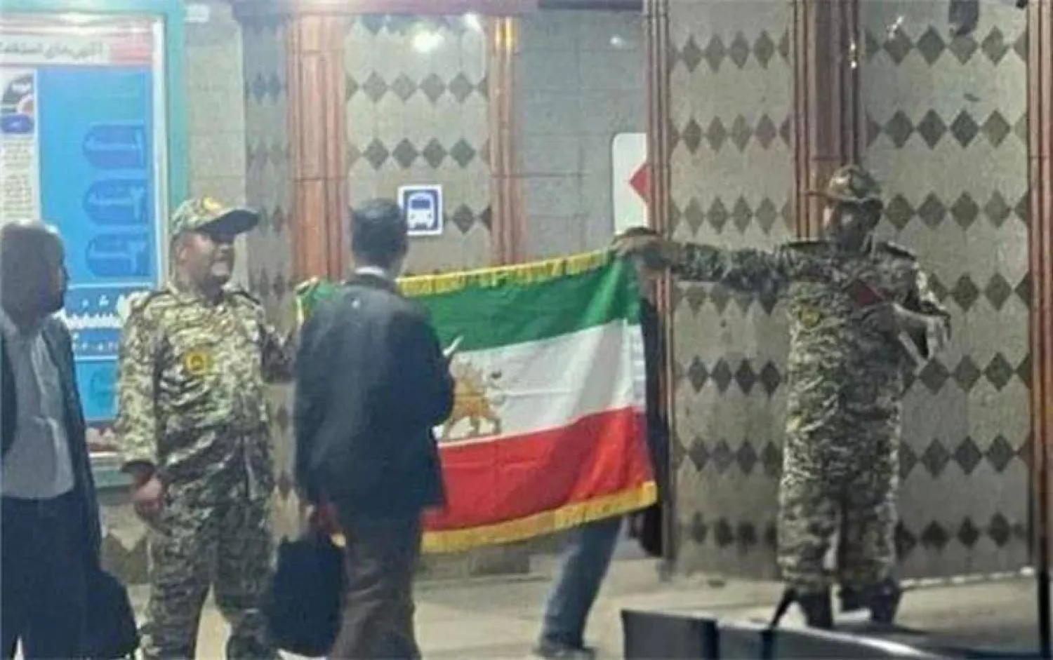 الرجلان وهما يلوّحان بعلم يحمل شعار «الأسد والشمس» المرتبط بنظام الشاه السابق (وكالة فارس)