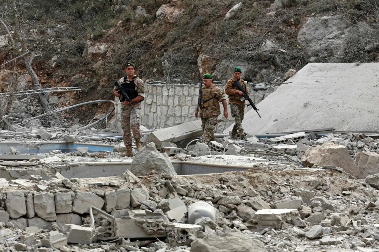جنود تابعون للجيش اللبناني يتفقدون موقع غارة إسرائيلية في قرية طير فلساي بالقرب من الليطاني في جنوب لبنان أمس (أ.ف.ب) 