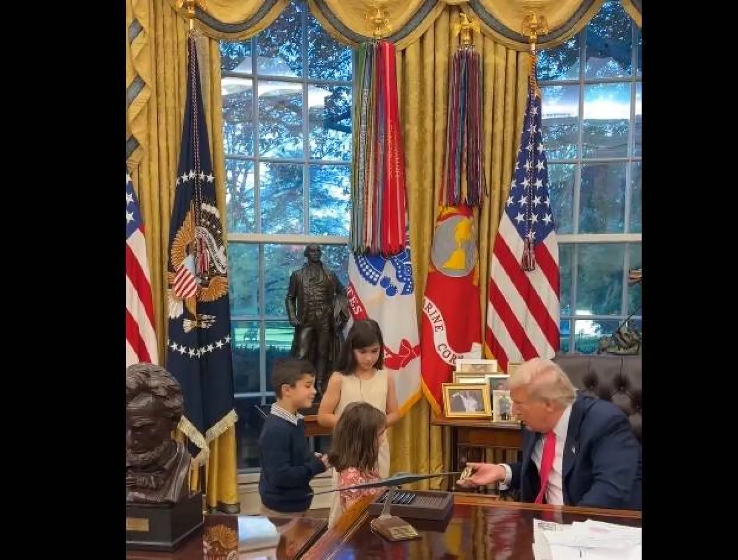 لقطة شاشة تُظهر الرئيس الأميركي دونالد ترمب يقدم هدايا صغيرة لأطفال في مكتبه البيضاوي بالبيت الأبيض (إكس)