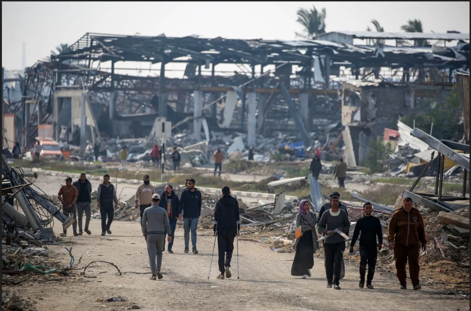 فلسطينيون يسيرون على طول طريق صلاح الدين بالنصيرات في طريقهم إلى الجزء الشمالي من قطاع غزة (أ.ف.ب)