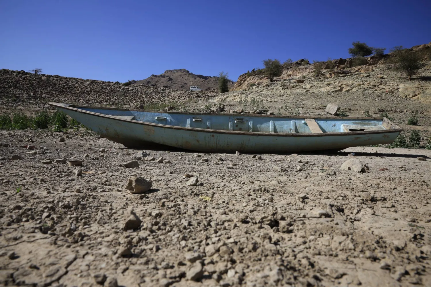 قارب مهجور يرقد في خزان مائي جفّ بفعل الجفاف على مشارف صنعاء (إ.ب.أ)