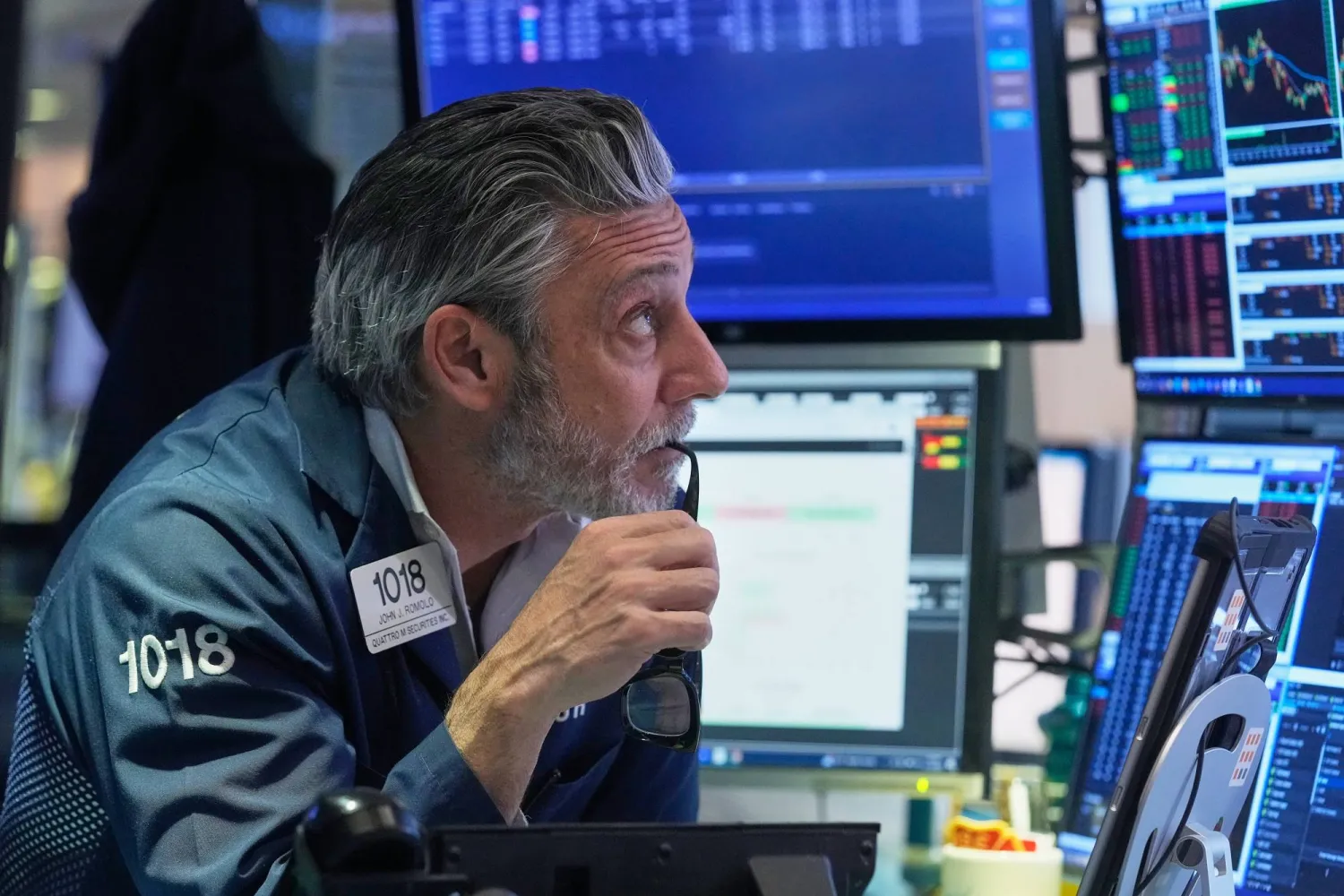 متداول ينظر إلى شاشات تعرض مؤشرات الأسهم في بورصة نيويورك (أ.ب)