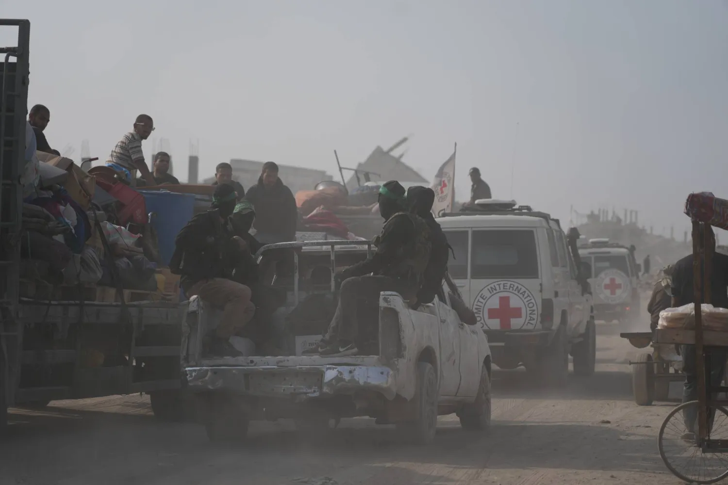 مسلحون من حركة «حماس» يتوجهون برفقة أعضاء اللجنة الدولية للصليب الأحمر إلى شرق مدينة غزة للبحث عن جثث الرهائن (أ.ب)