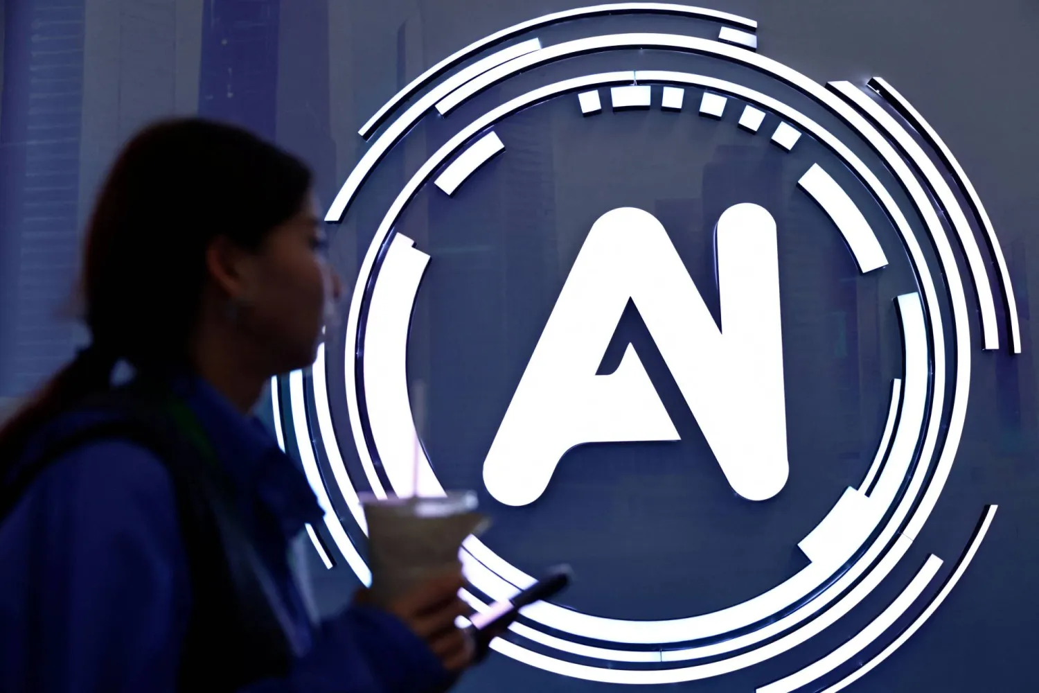 سيدة تمر بجوار لافتة كتب عليها «الذكاء الاصطناعي» في معرض حول الإنترنت بالصين (رويترز)