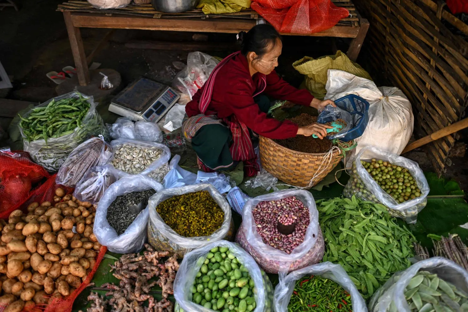 بائعة خضراوات وفواكه في أحد أسواق ميانمار (أ.ف.ب)