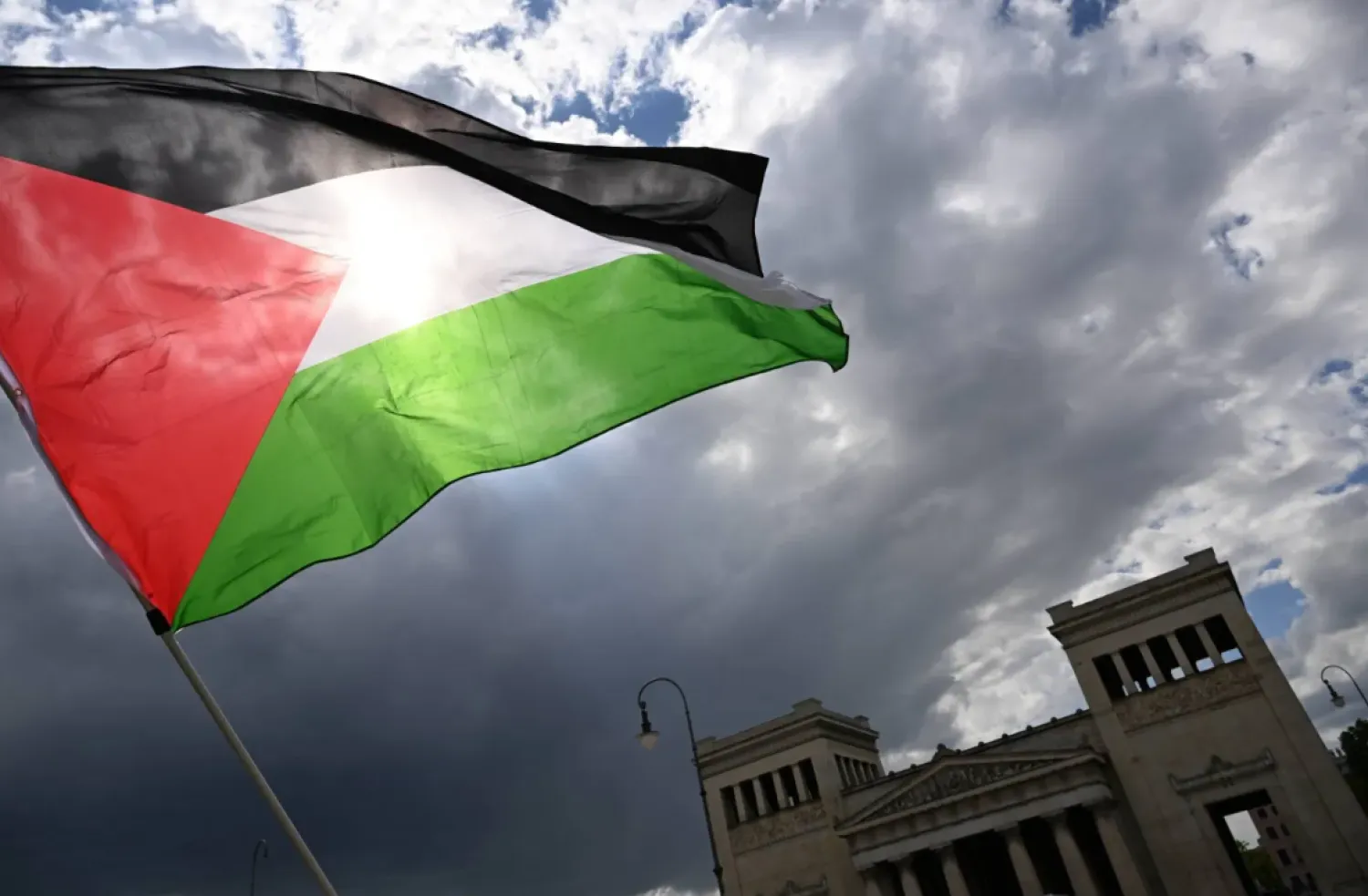 17 May 2025, Bavaria, Munich: A protester waves a Palestinian flag during a demonstration on Koenigsplatz. (dpa)
