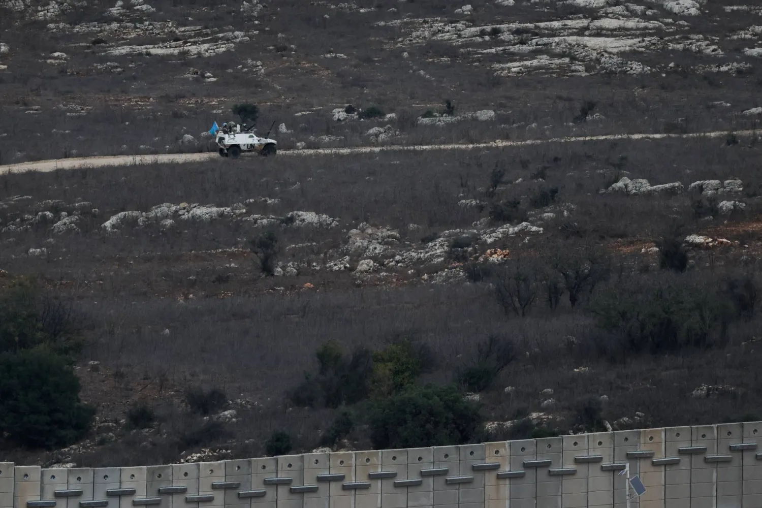 A UN vehicle drives near a concrete wall along Lebanon's southern border which, according to the Lebanese presidency, extends beyond the "Blue Line", a UN-mapped line separating Lebanon from Israel and the Israeli-occupied Golan Heights, as seen from northern Israel, November 16, 2025. REUTERS/Shir Torem