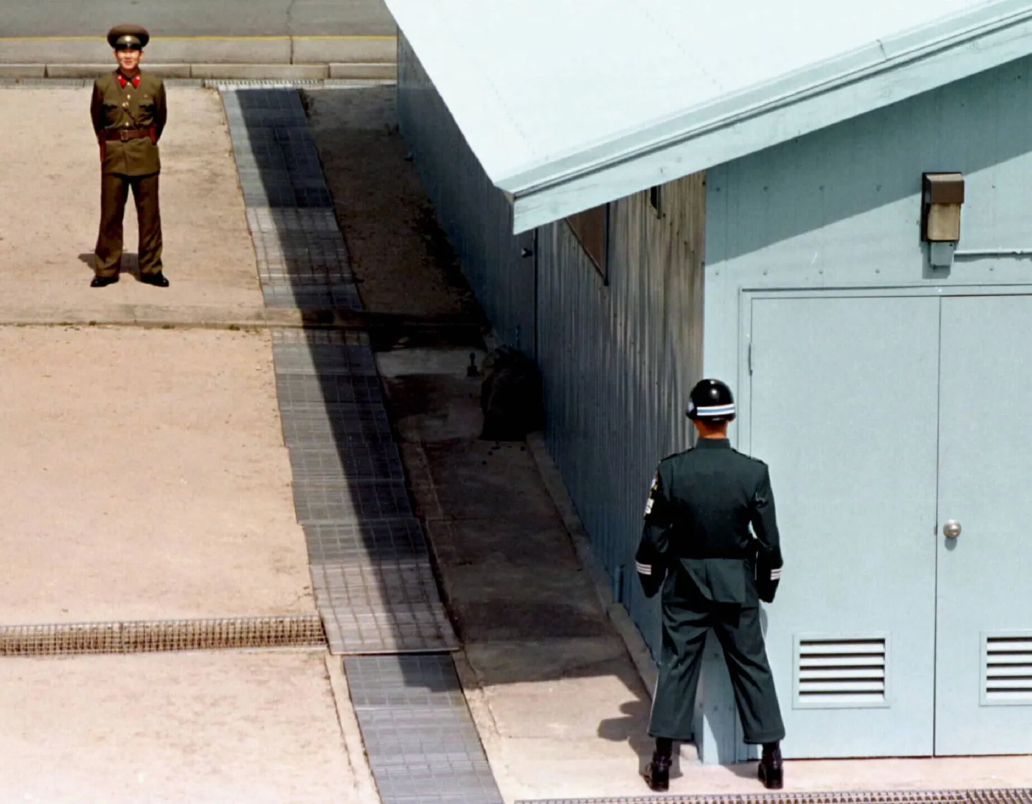 جندي من كوريا الشمالية يقف في مواجهة جندي من كوريا الجنوبية عند خط ترسيم الحدود بين البلدين (أرشيفية - رويترز)