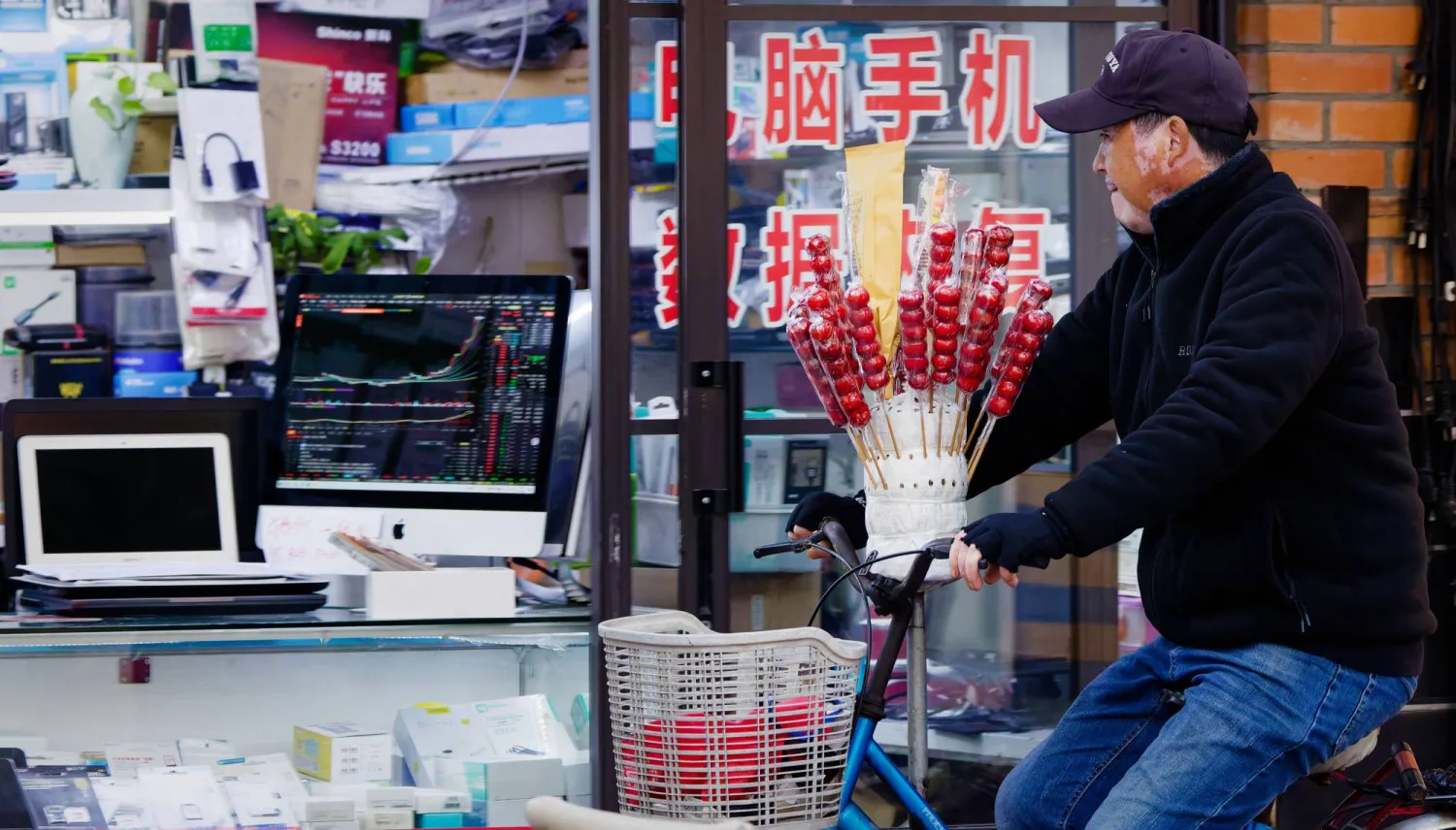 رجل يمر أمام متجر لبيع الإلكترونيات بمدينة شنغهاي الصينية (إ.ب.أ)