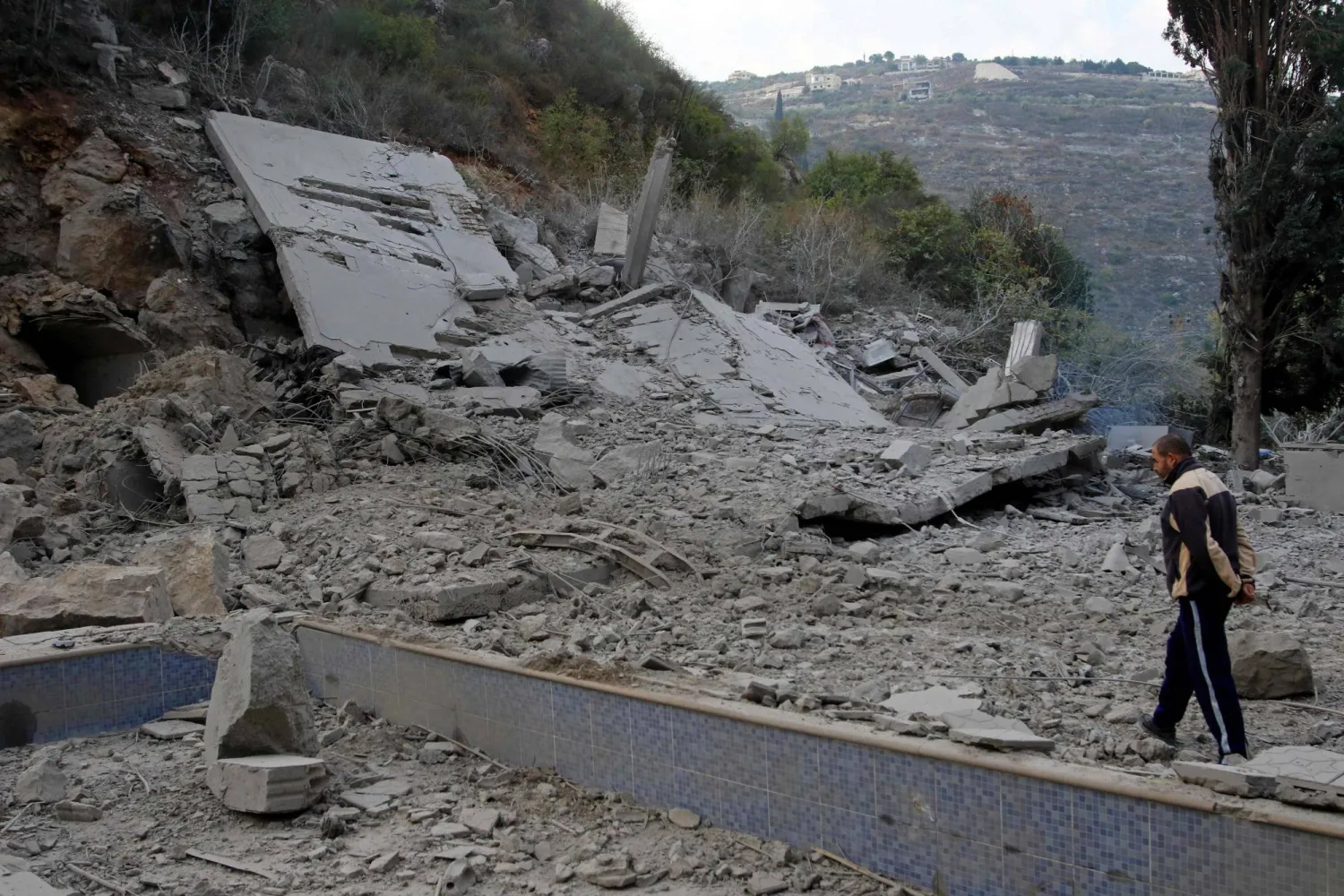 مواطن يعاين موقعاً تم استهدافه في بلدة طير فليسا في الجنوب بغارة إسرائيلية الأسبوع الماضي (أ.ف.ب)