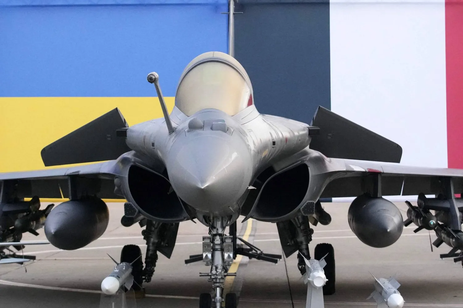 This photograph shows a Rafale jet fighter with Ukraine's and France's national flags in the background before the arrival of Ukraine's President Volodymyr Zelensky at the Villacoublay air base, in Velizy-Villacoublay, near Paris on November 17, 2025. (AFP)