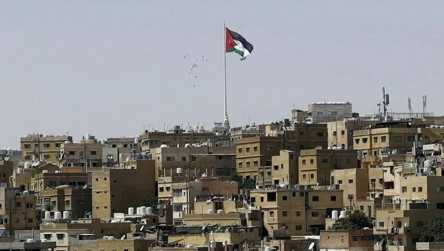  A general view taken from Jabal Al Qala district shows a Jordanian flag fluttering above the Jordanian capital Amman. (AFP) 