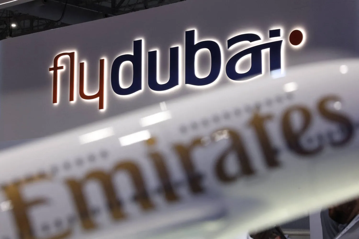 The logos of 'flydubai' and 'Emirates' feature on displays at the Dubai Airshow, in Dubai, United Arab Emirates, November 17, 2025. REUTERS/Amr Alfiky