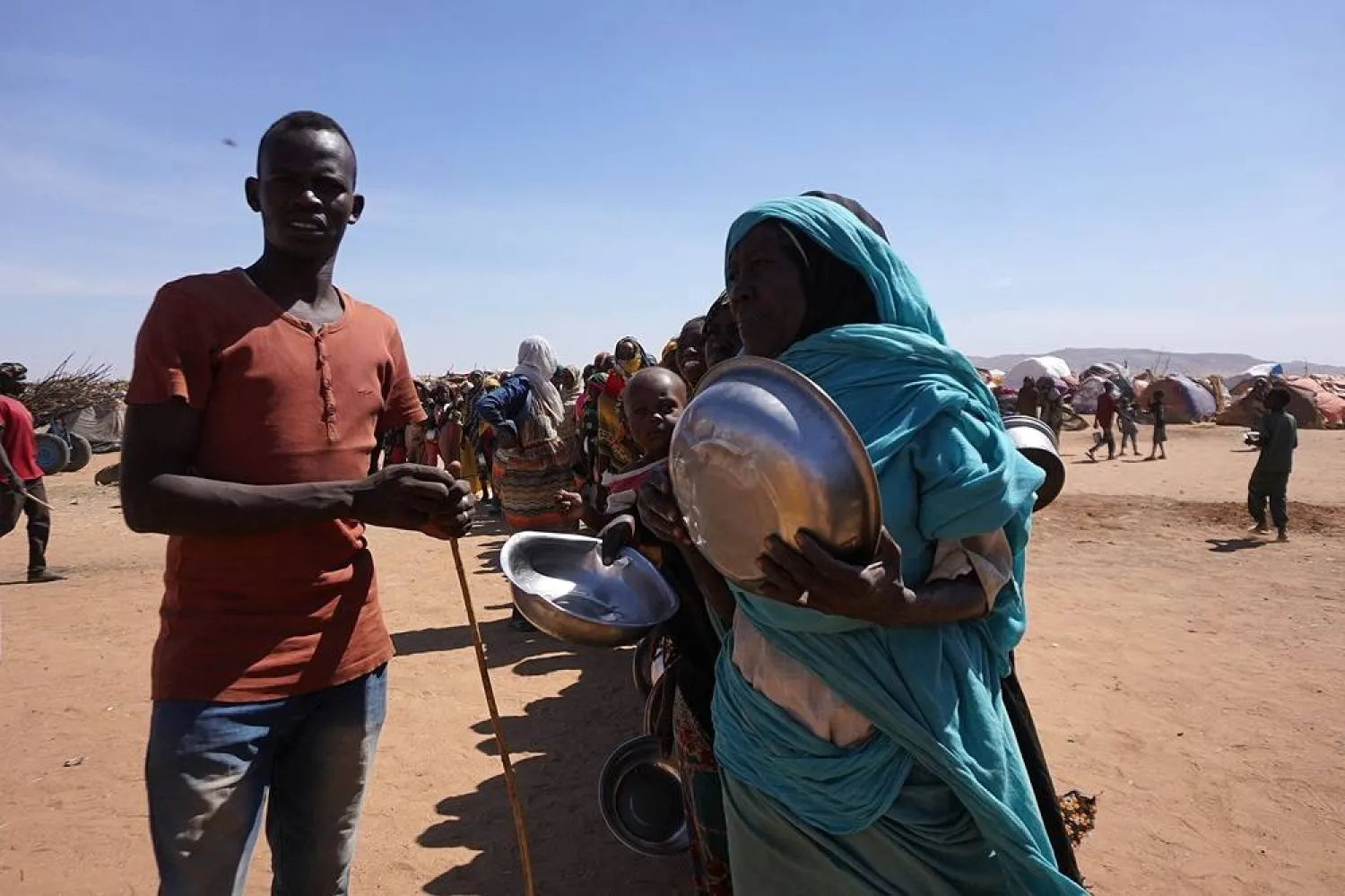 A handout picture released by the International Committee of the Red Cross (ICRC) on November 18, 2025 shows displaced civilians who have fled violence in el-Fasher gathering by makeshift camps in the city of Tawila. (Mohamed Jamal / ICRC / AFP) 