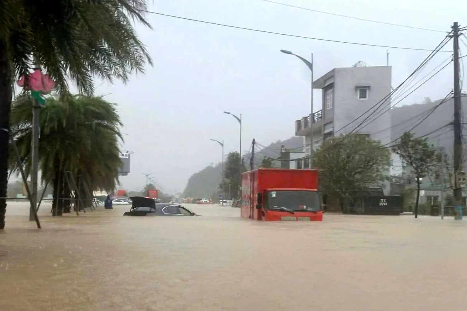 19 November 2025, Vietnam, Quy Nhon: A truck drives through a flooded street in Quy Nhon after heavy rain and landslides caused flooding in Vietnam. Photo: Tran Van Thong/dpa