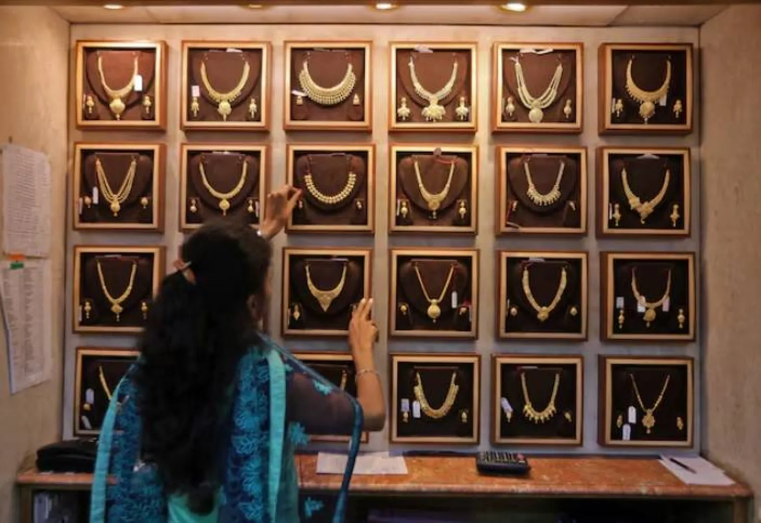 بائعة في صالة مجوهرات ذهبية في مومباي الهند (رويترز)