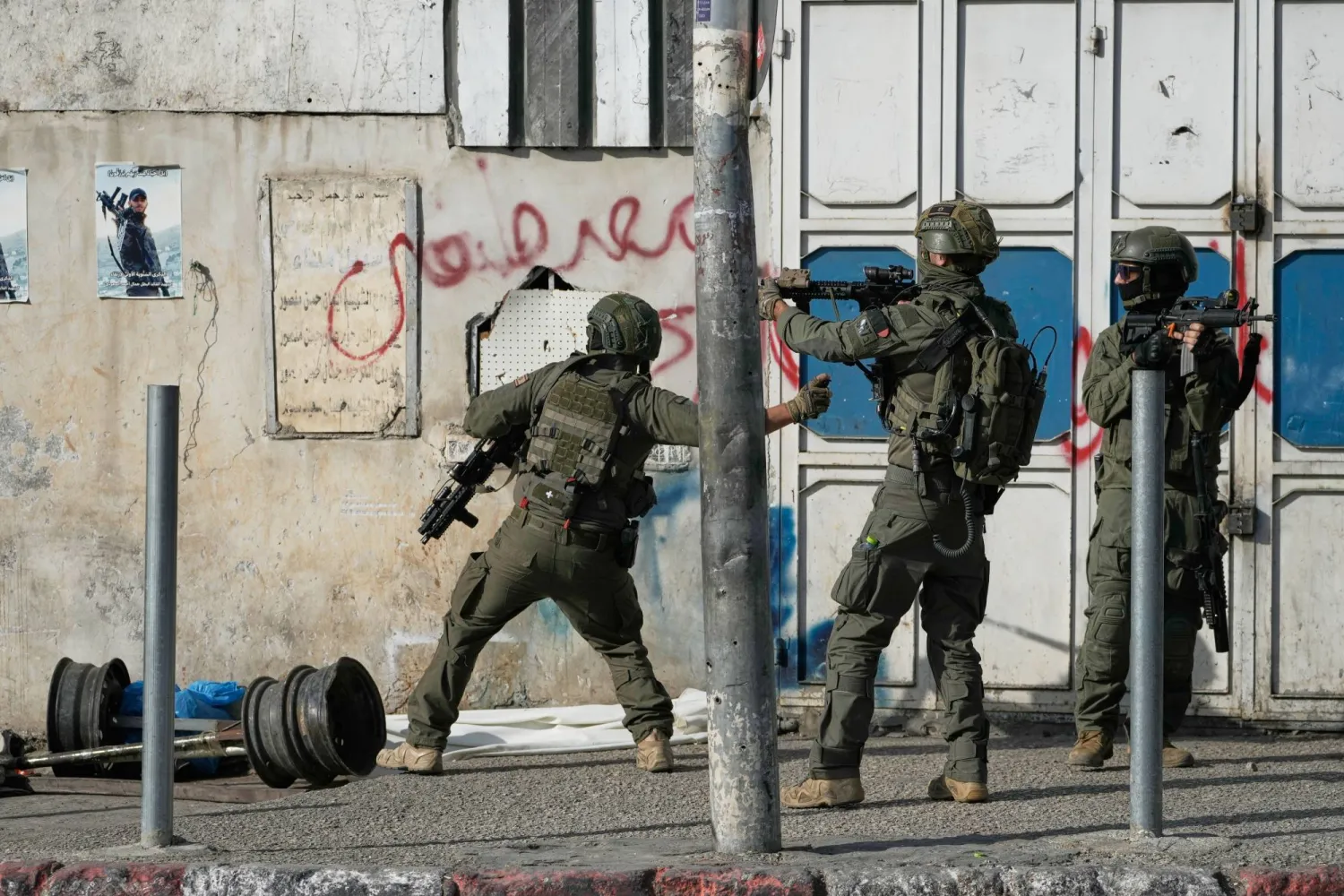 جنود إسرائيليون يوجّهون أسلحتهم خلال غارة عسكرية في مدينة نابلس الفلسطينية بالضفة الغربية اليوم (أ.ب)