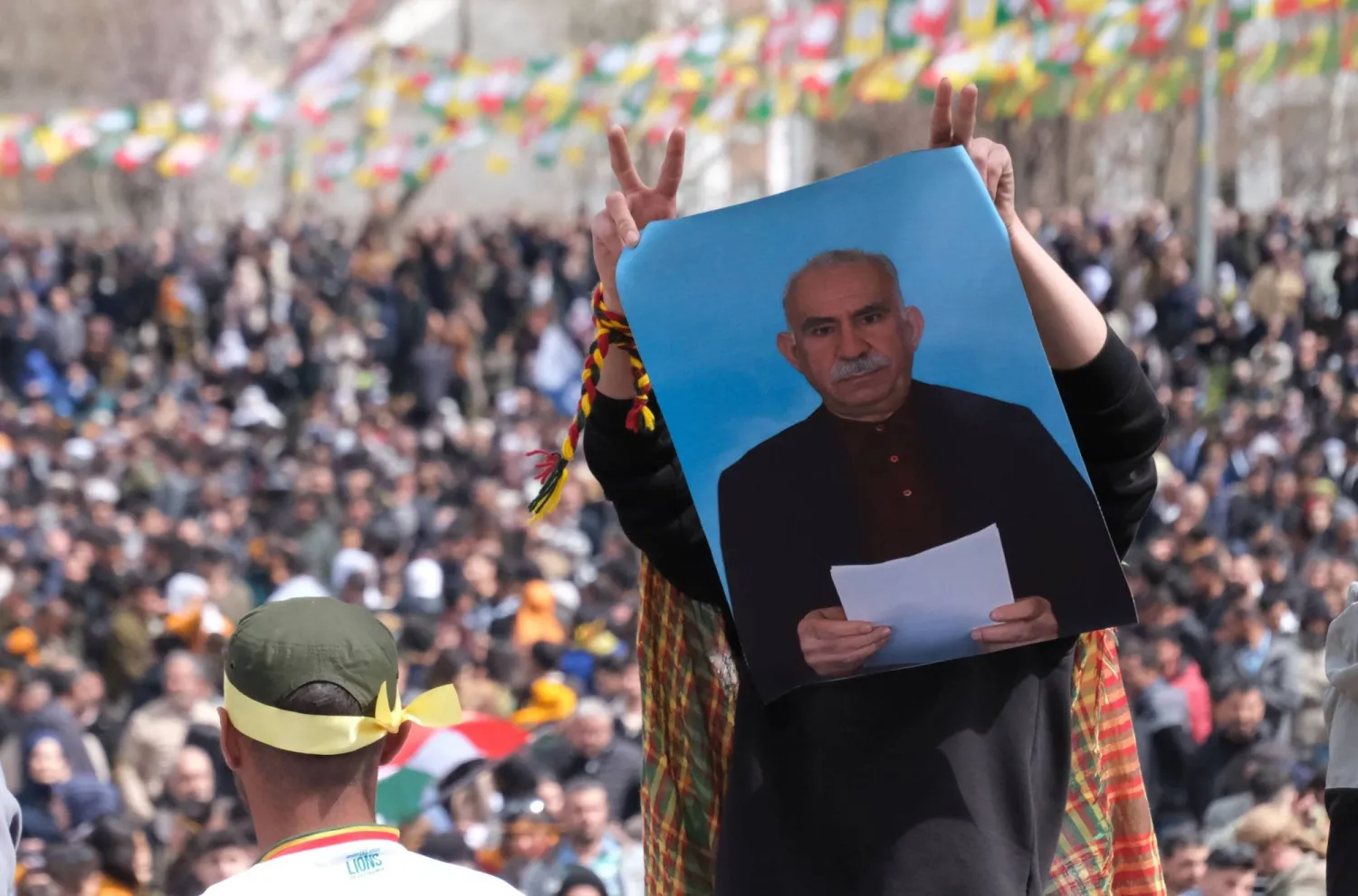 امرأة كردية ترفع صورة لأوجلان أثناء قراءة ندائه لـ«حزب العمال الكردستاني» لحل نفسه وإلقاء أسلحته خلال احتفالات عيد النوروز  جنوب شرقي تركيا 21 مارس الماضي (رويترز)