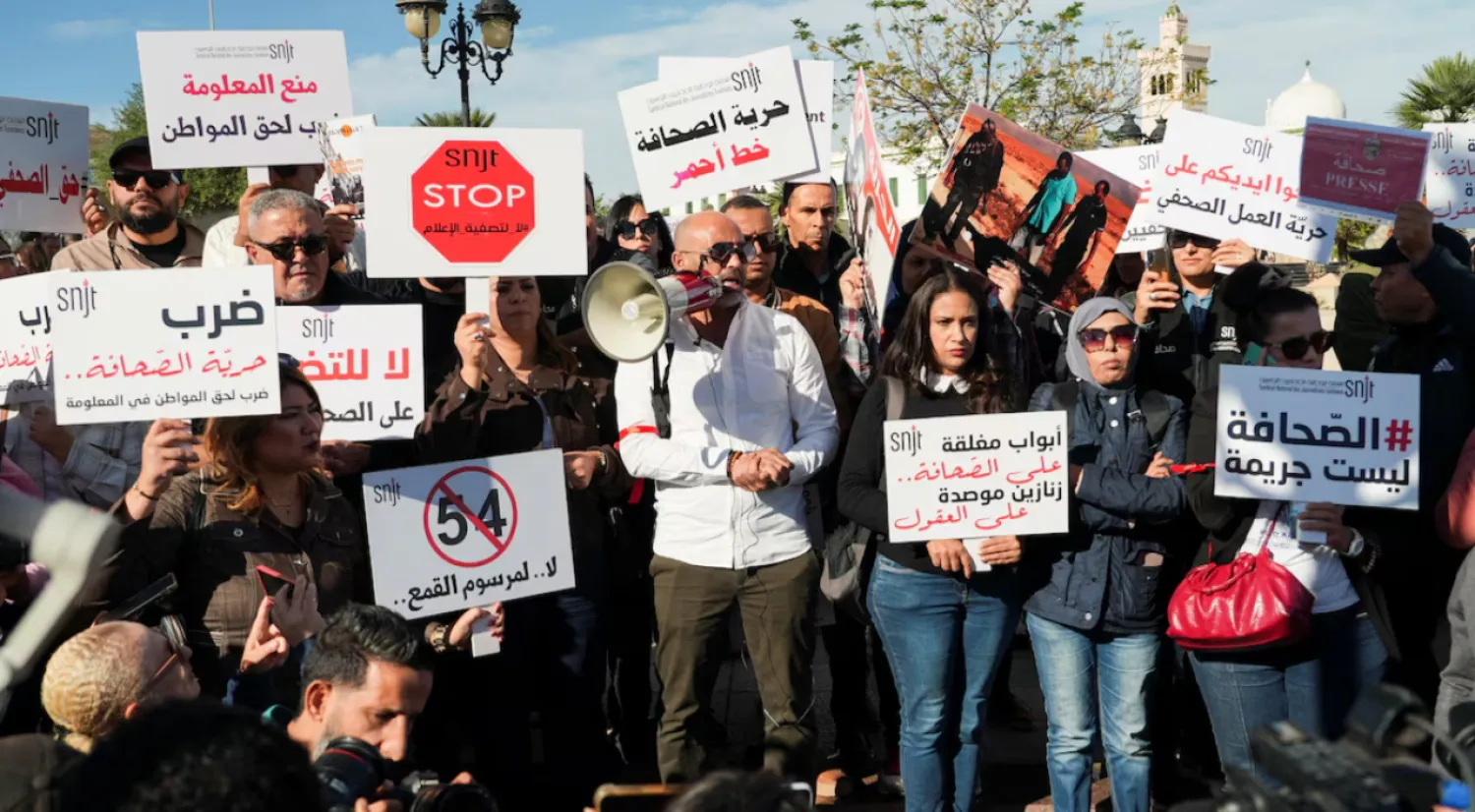 Tunisian journalists rally near the government's office, holding signs to protest press restrictions- REUTERS/Jihed Abidellaoui 