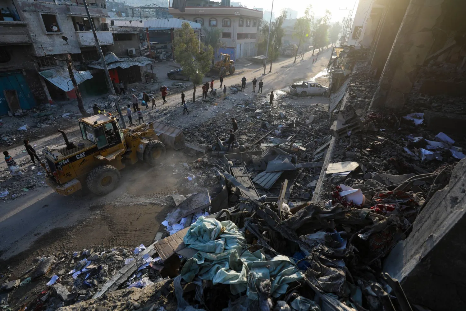 فلسطينيون يتفقدون مبنى مدمراً بعد غارة جوية إسرائيلية في حي الزيتون في مدينة غزة 20 نوفمبر 2025 (إ.ب.أ)