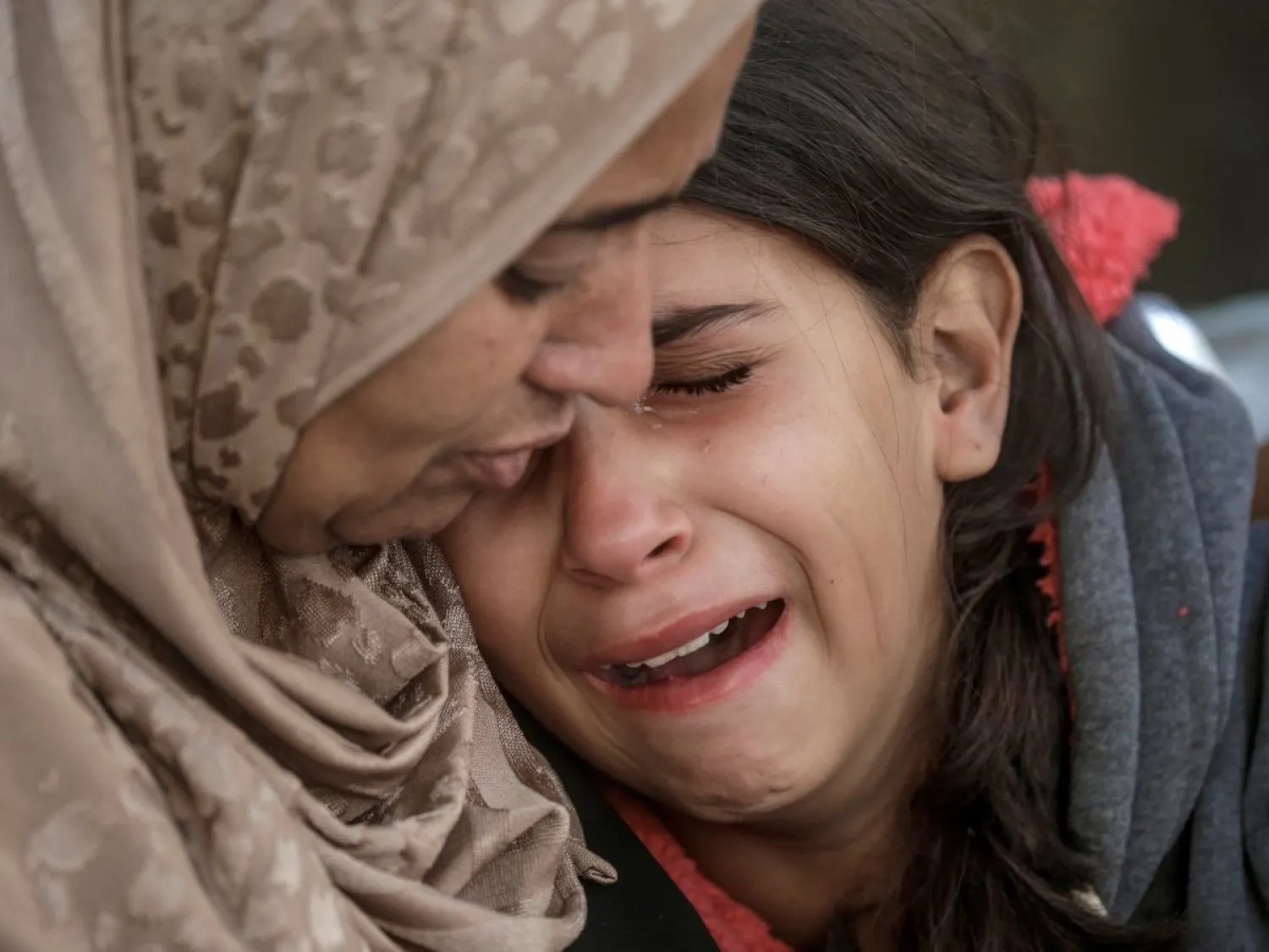 فلسطينيتان تنعيان مقتل أقارب لهما جراء غارة جوية إسرائيلية على مستشفى الشتاء في مدينة أمس (إ.ب.أ)