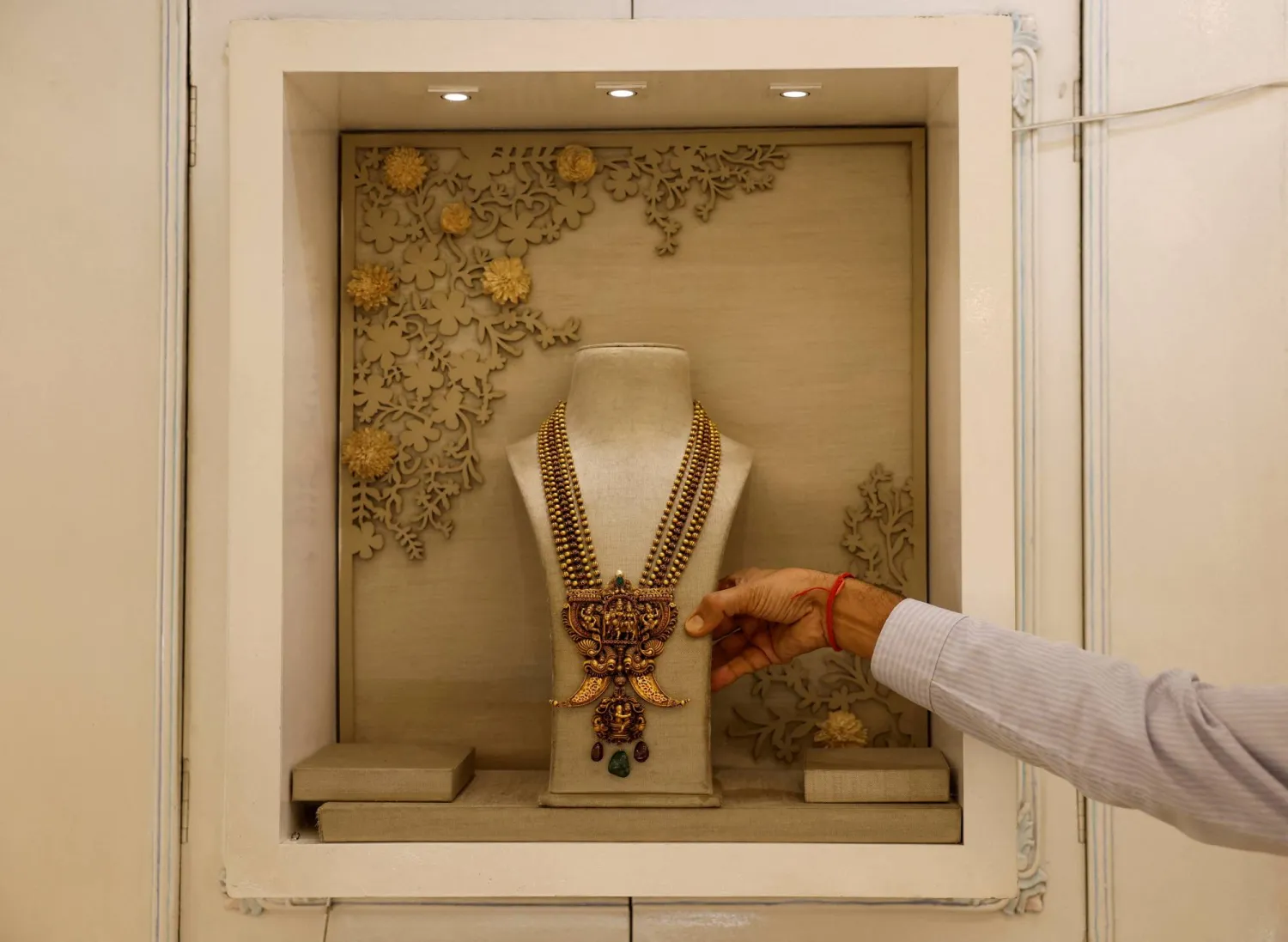 FILE PHOTO: A salesman shows a gold necklace on display inside a jewelry showroom in Kolkata, India, October 18, 2024. REUTERS/Sahiba Chawdhary/File Photo