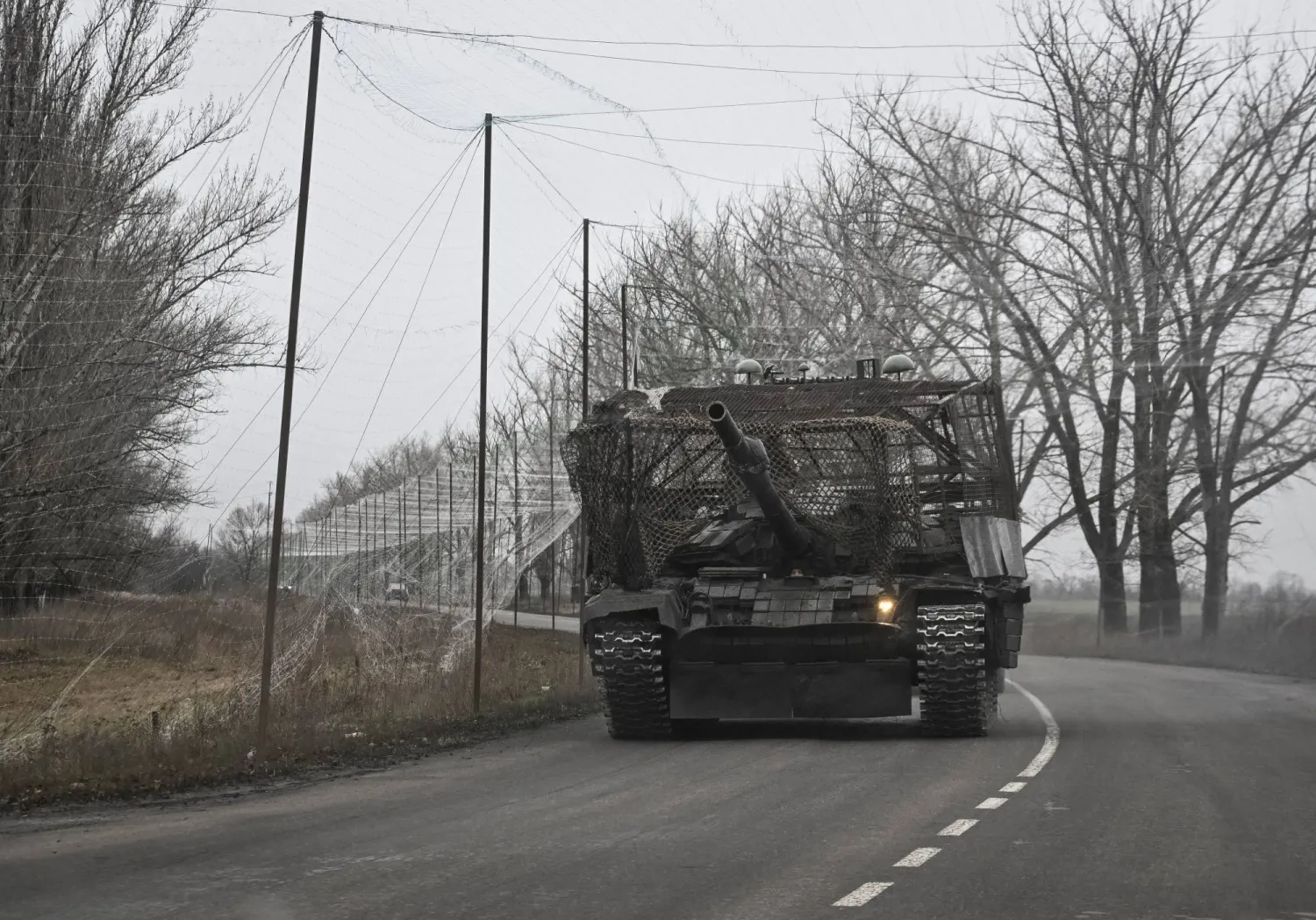 Ukrainian servicemen ride a tank installed with a grille and electronic warfare systems as combat drones protection near a front line, amid Russia's attack on Ukraine, near the town of Pokrovsk in Donetsk region, Ukraine November 20, 2025. REUTERS/Stringer