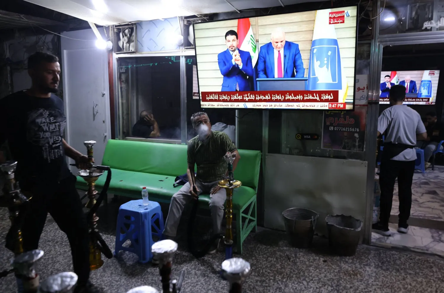 عراقيون يتجمعون لمشاهدة إعلان النتائج النهائية للانتخابات في مقهى بمنطقة الكرادة في بغداد الاثنين الماضي (أ.ف.ب)