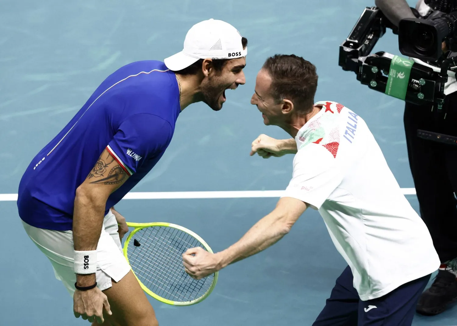 الإيطالي ماتيو بيريتيني يحتفل مع قائد إيطاليا فليبو فولاندري بالفوز في ديفيز (رويترز)