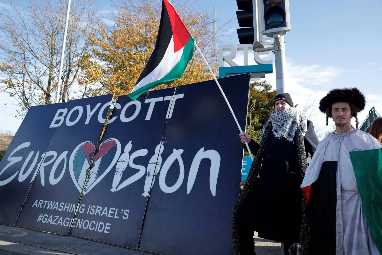 Pro-Palestinian protestors hold a flag and a banner outside the RTE (Radio Telefis Eireann) Irish public service broadcaster television studios as demonstrators call for an Irish boycott of the 2026 Eurovision Song Contest if there is Israeli participation, in Dublin, Ireland, November 1, 2025. (Reuters)
