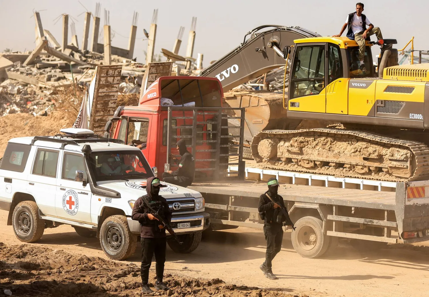 مسلحون من «حماس» يرافقون أعضاء الصليب الأحمر نحو منطقة داخل ما يسمى «الخط الأصفر» الذي انسحبت إليه القوات الإسرائيلية بموجب وقف إطلاق النار (رويترز)