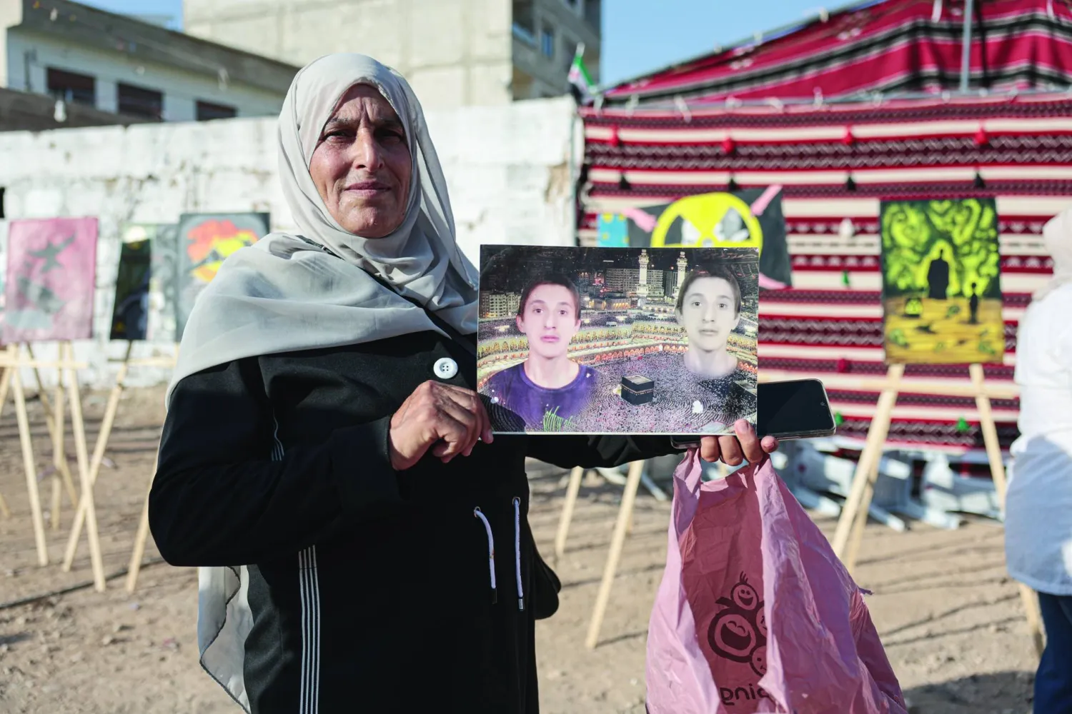 سوريّة تحمل صورة طفل قُتل في هجوم الغوطة الكيماوي عام 2013 خلال احتفال لإحياء ذكرى الهجوم في 21 أغسطس 2025 (إ.ب.أ)