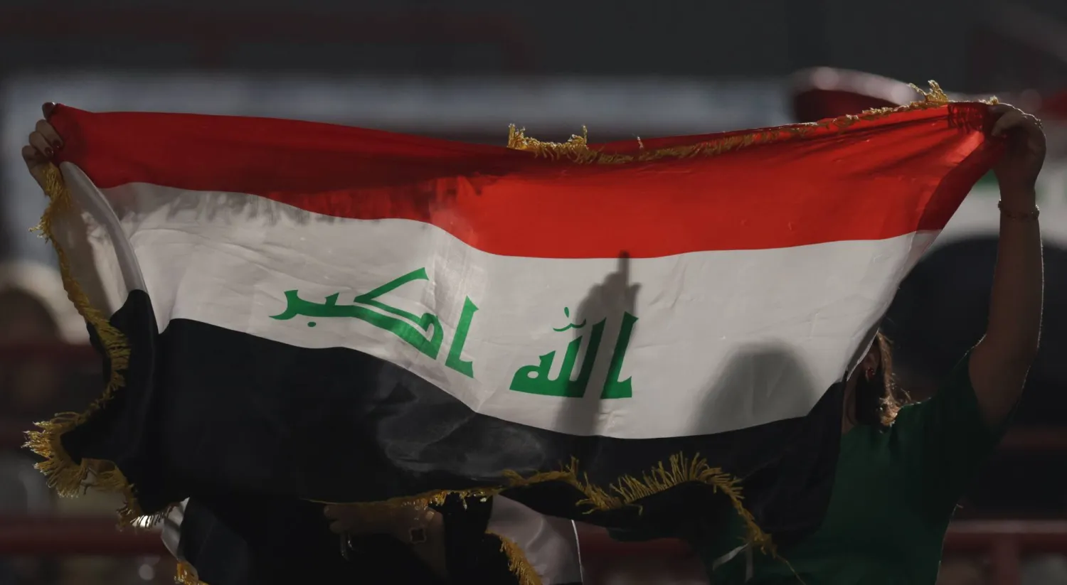 A fan holds an Iraqi flag during the FIFA World Cup 2026 Asian qualifiers play-off 1st leg soccer match between UAE and Iraq in Abu Dhabi, United Arab Emirates, 13 November 2025.  (EPA)