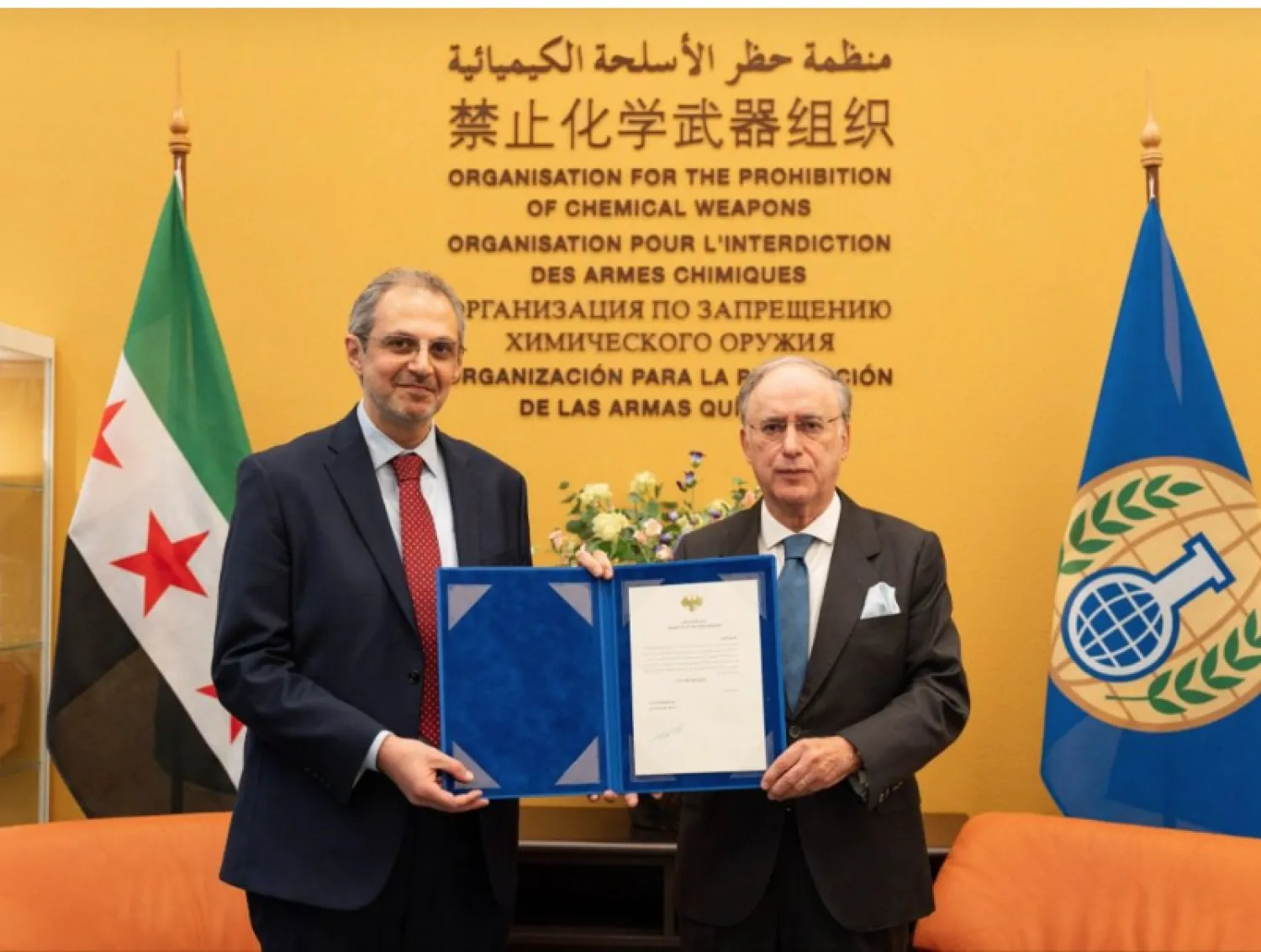 Mohammad Katoub (left) assumes his duties as Syria’s representative to the Organization for the Prohibition of Chemical Weapons (Al-Ikhbariyah Syria). 