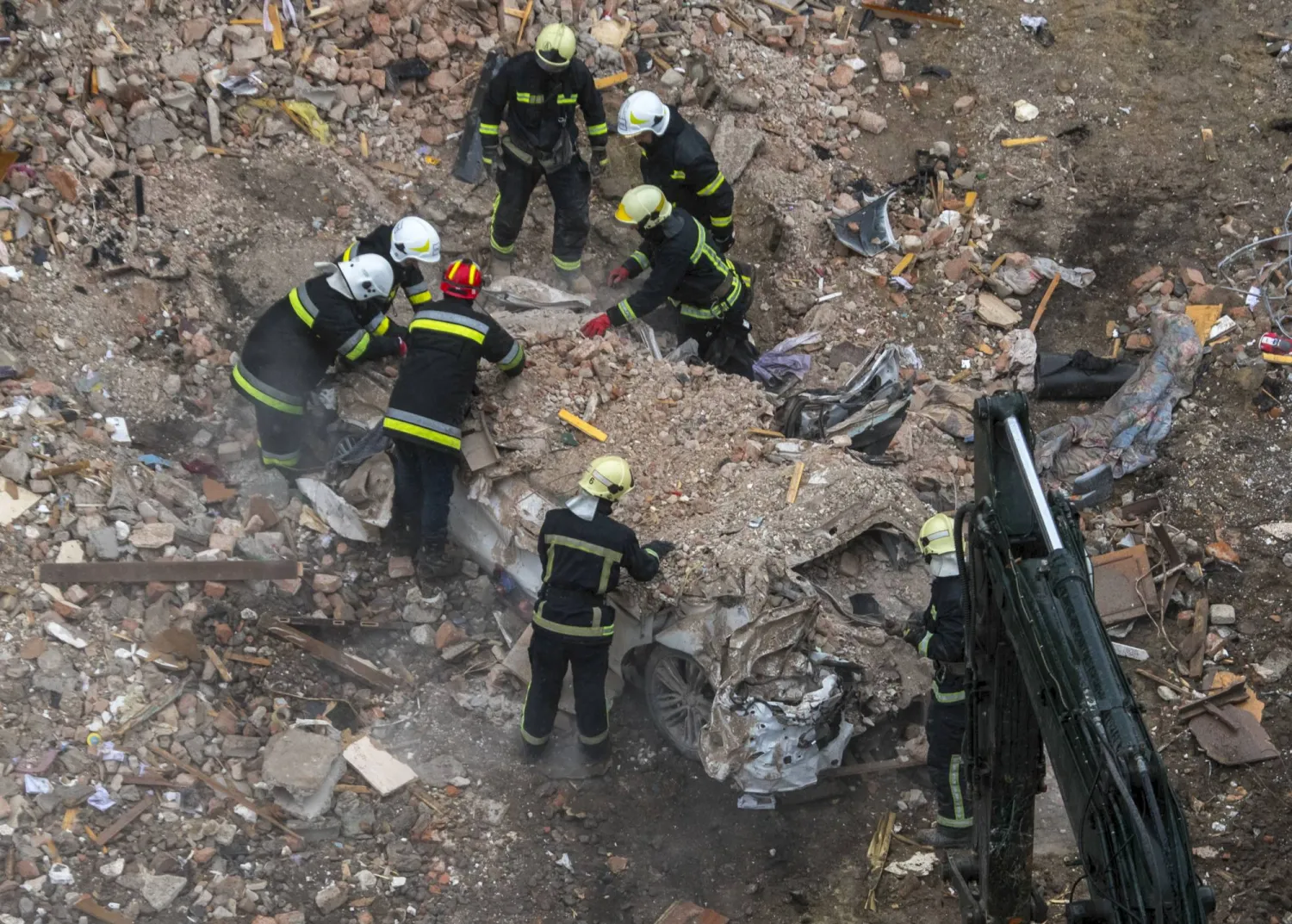 عمال إنقاذ أوكرانيون في موقع غارة روسية على غرب أوكرانيا (إ.ب.أ)