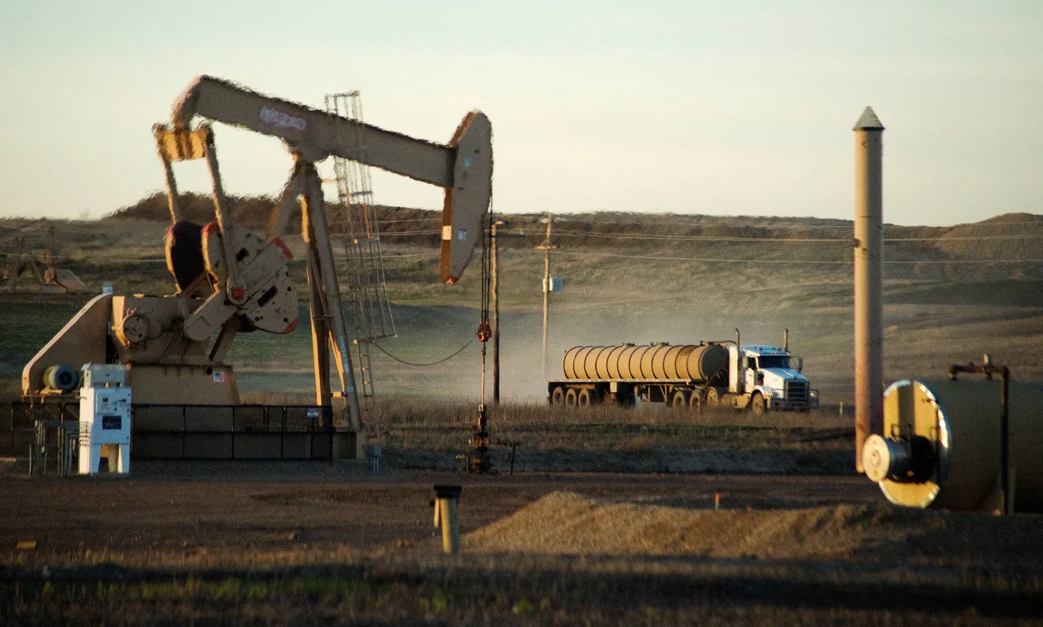 FILE PHOTO: A service truck drives past an oil well on the Fort Berthold Indian Reservation in North Dakota, November 1, 2014.  REUTERS/Andrew Cullen/File Photo