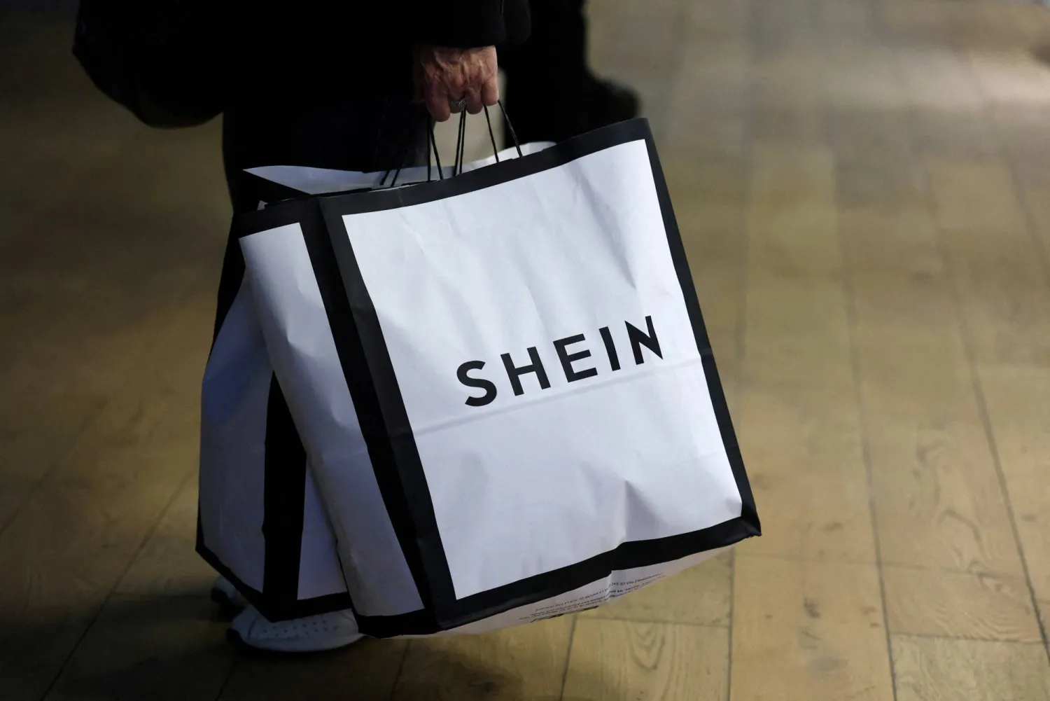 FILE PHOTO: A customer holds shopping bags with a Shein logo in the first physical space of Chinese online fast-fashion retailer Shein on the day of its opening inside the Le BHV Marais department store, the Bazar de l'Hotel de Ville, in Paris, France, November 5, 2025. REUTERS/Sarah Meyssonnier/File Photo