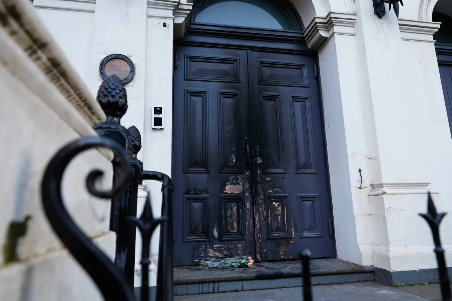 Flowers are left at the fire-damaged door of the East Melbourne Synagogue in Melbourne, Australia, July 7, 2025, following an arson attack. (Con Chronis/AAP Image via AP)