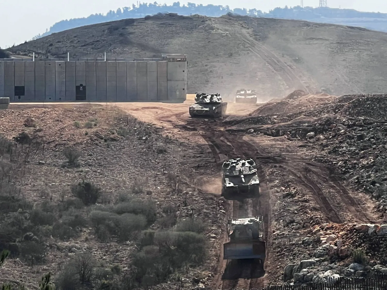 Israeli tanks and a D9 bulldozer cross the Israel-Lebanon border into Israel, as seen from northern Israel, November 23, 2025. REUTERS/Avi Ohayon